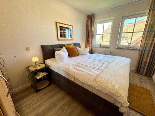 a bedroom with a bed with white sheets and pillows at Birkenhof App 44 in Wustrow