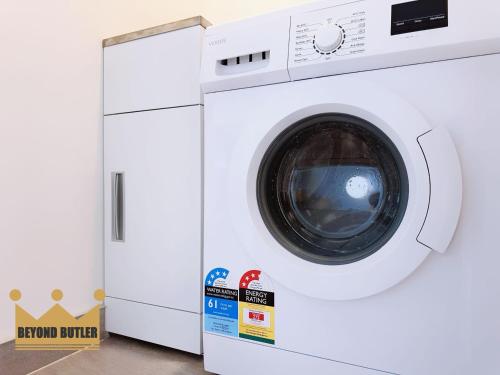 a white washing machine with a box next to it at Discover Avondale - 10 Sec Walk to Sunday Market in Auckland