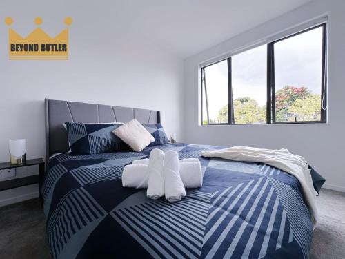 a bedroom with a bed with white towels on it at Discover Avondale - 10 Sec Walk to Sunday Market in Auckland