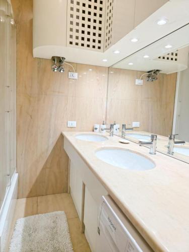 a bathroom with two sinks and a mirror at Poerio Apartment Your Venice Gateway in Mestre in Venice