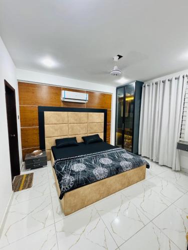 a bedroom with a large bed in a room at Bahria Breeze Apartment in Karachi