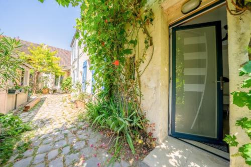 a door to a building with ivy growing on it at Cocon champêtre en hyper-centre in Antony