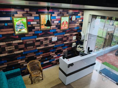a room with a brick wall with paintings on it at Hotel Rudra in Haldwāni