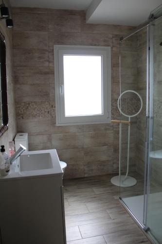 a bathroom with a shower and a sink and a window at AT El rincón de Bohonal in Bohonal de Ibor
