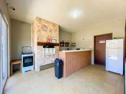 a kitchen with a stove and a refrigerator in a room at Maga Inn House - Centro in Blumenau