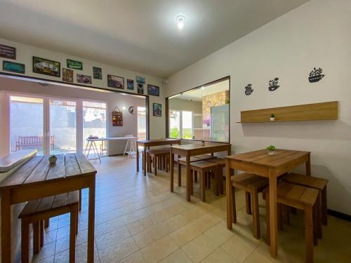 a dining room with wooden tables and chairs at Maga Inn House - Centro in Blumenau