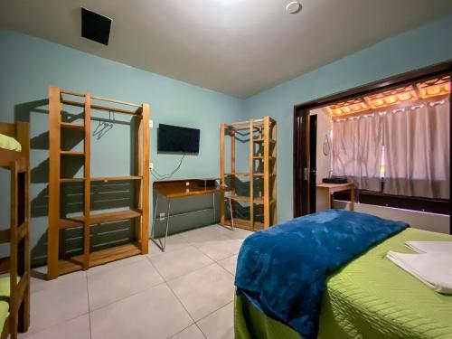 a bedroom with a bed and a room with bunk beds at Maga Inn House - Centro in Blumenau