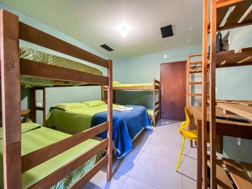 a room with two bunk beds and a desk at Maga Inn House - Centro in Blumenau