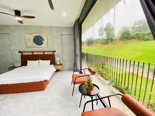 a bedroom with a bed and a large window at Rolling Hill Resort in Xóm Trông