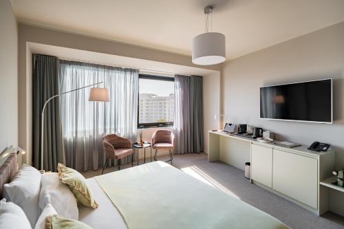 a hotel room with a bed and a flat screen tv at Millennium Hub & Hotel in Constanţa