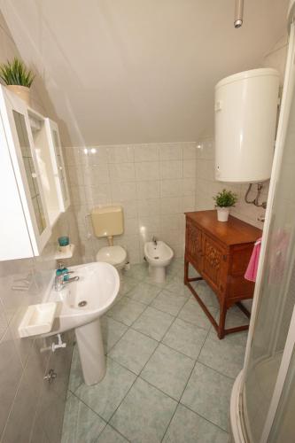 a bathroom with a sink and a toilet at Apartmani Kristijan in Jesenice