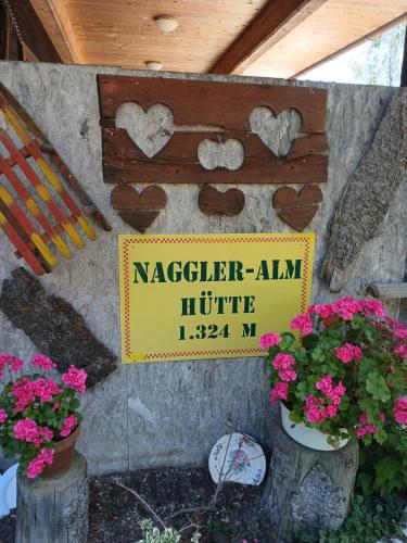 a sign on a wall with some flowers and a sign at Pension & Apartments Weissbriach in Weissbriach
