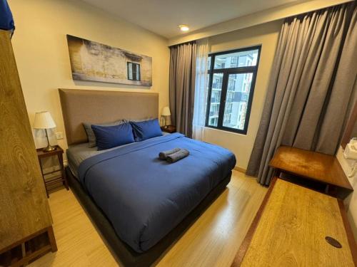 a bedroom with a large bed with blue pillows at Timurbay Seafront Residences by Nature Home in Kuantan