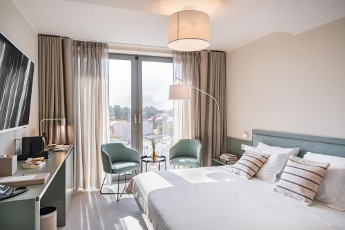 a hotel room with a bed and a desk and chairs at Millennium Hub & Hotel in Constanţa
