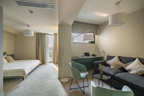 a hotel room with a bed and a couch at Millennium Hub & Hotel in Constanţa
