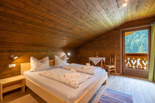 a bedroom with a bed in a wooden room at Ferienhaus Oberschneider in Selva dei Molini