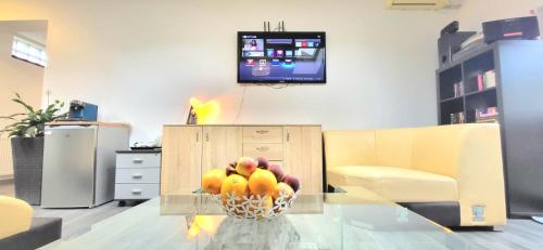 a bowl of fruit on a glass table in a living room at Guest house in Otopeni