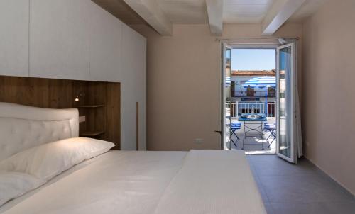 a bedroom with a white bed and a balcony at Holiday Suite Versilia in Viareggio