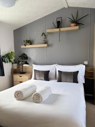 a bedroom with a large white bed with pillows at Padstow Holiday Base Bright Two Bedroom Lodge at Seven Bays in Saint Merryn