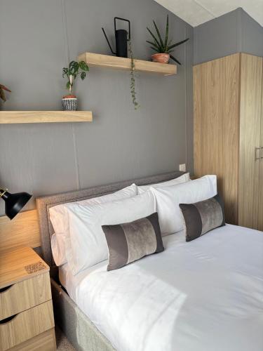 a bedroom with a bed with white sheets and pillows at Padstow Holiday Base Bright Two Bedroom Lodge at Seven Bays in Saint Merryn