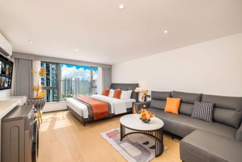 a living room with a couch and a bed at Mihua International Apartment - Guangzhou Yangang Subway Station Branch in Guangzhou