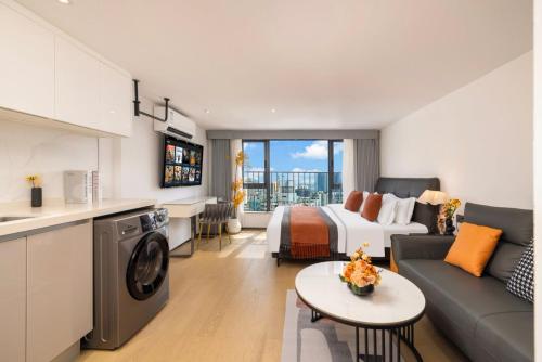 a hotel room with a bed and a couch at Mihua International Apartment - Guangzhou Yangang Subway Station Branch in Guangzhou