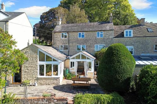 an exterior view of a large stone house at Whitehall Cottage in Painswick