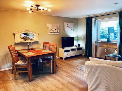 a living room with a table and a television at Christianes Apartment - Ebstorf in Ebstorf