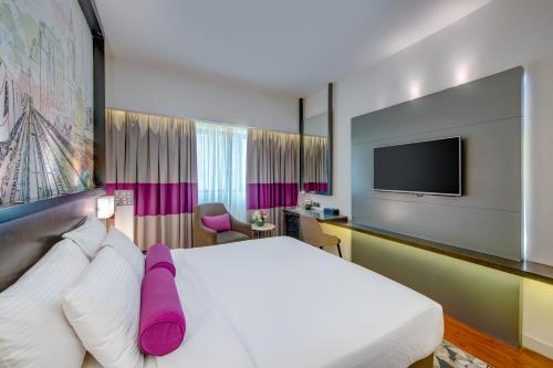 a hotel room with a bed and a flat screen tv at Howard Johnson Plaza by Wyndham Dubai Deira in Dubai