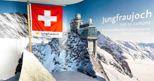 a flag on top of a mountain with a flag at Studio 5min Blausee / 20min Interlaken / WIFI in Kandergrund