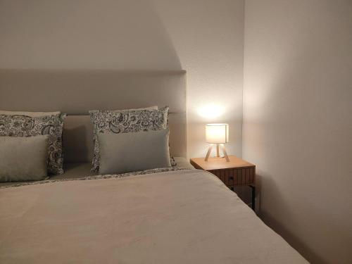 a bedroom with a bed with a lamp on a night stand at Studio 5min Blausee / 20min Interlaken / WIFI in Kandergrund