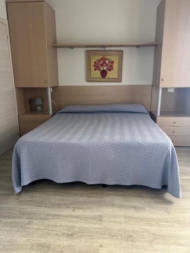 a bedroom with a bed with a blue comforter at Vista Mare in Pineto