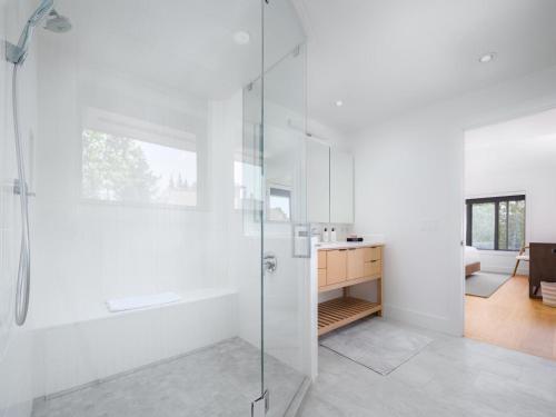 a white bathroom with a shower and a sink at RMR: Tram Tower 5 Condo in Teton Village in Teton Village