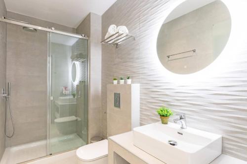 a white bathroom with a sink and a shower at Villa Bougainvillea Boutique 2 by Villa Plus in Marathias