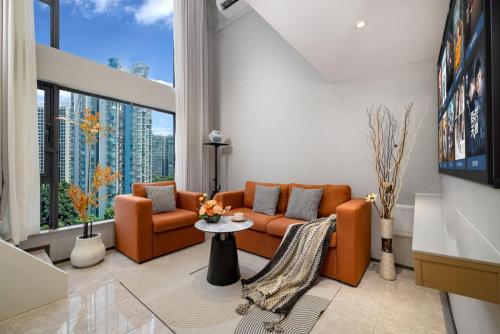 a living room with orange furniture and a large window at Mihua International Apartment - Guangzhou Yangang Subway Station Branch in Guangzhou