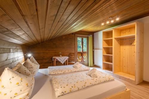 two beds in a room with a wooden ceiling at Ferienhaus Oberschneider in Selva dei Molini
