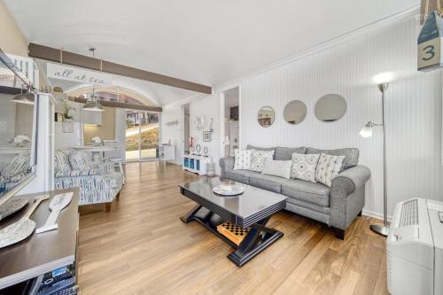 a living room with a couch and a table at Waterfront condo -shop-beach-bike-boat-pool-chill in Saugatuck
