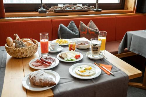 a table with breakfast foods and drinks on it at Hotel Garni Haus Tyrol in Obertauern