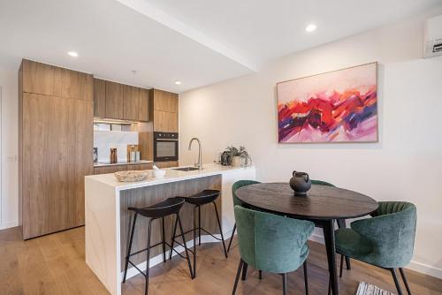 a kitchen and dining room with a table and chairs at High-Rise Balcony Unit with City Views Gym Pool in Melbourne