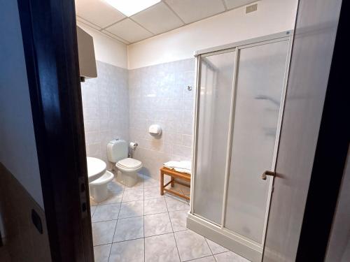a bathroom with a toilet and a glass shower at Hotel Mariuccia in Varese