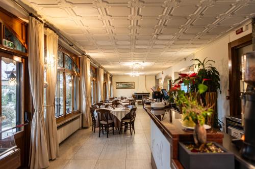 a restaurant with tables and chairs in a room at Hotel Mariuccia in Varese