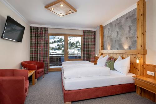 a hotel room with a bed and a chair at Hotel Garni Haus Tyrol in Obertauern
