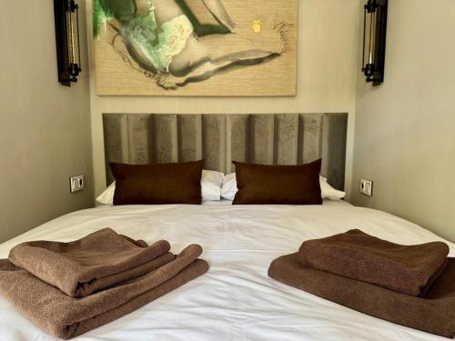 a bed with two towels sitting on top of it at Garden Residence - The Garage in Drahobudice