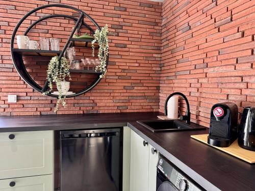 a kitchen with a sink and a brick wall at Garden Residence - The Garage in Drahobudice