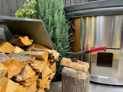 a large axe sticking out of a pile of wood at Garden Residence - The Garage in Drahobudice