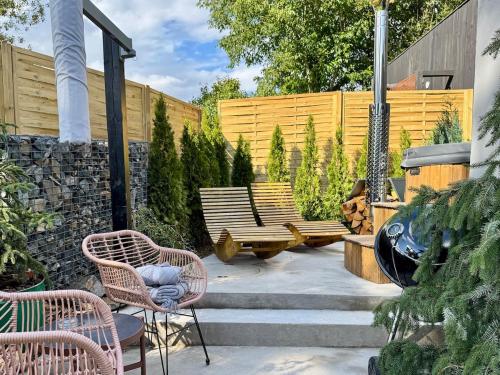 a patio with two chairs and two benches at Garden Residence - The Garage in Drahobudice