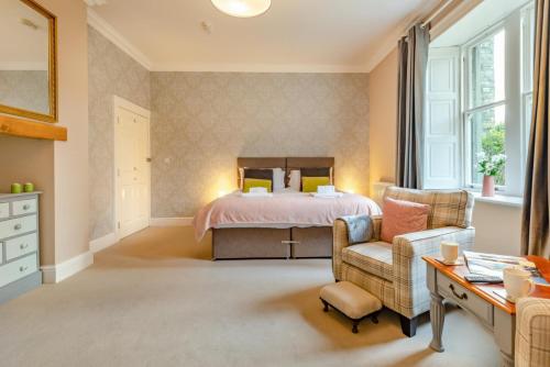 a bedroom with a bed and a chair and a desk at Bethby Beck Apartment Keswick at The Lairbeck in Keswick