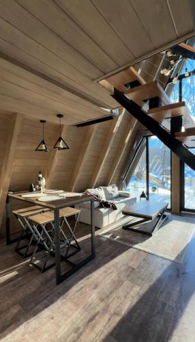 an attic dining room with a table and chairs at Grehit House in Kozmacz