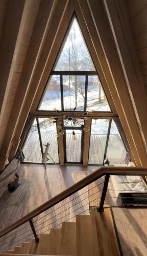 an attic room with a large window and stairs at Grehit House in Kozmacz