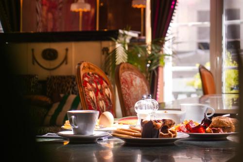 a table with plates of food and cups of coffee at Lisbon Art Stay Apartments Baixa in Lisbon